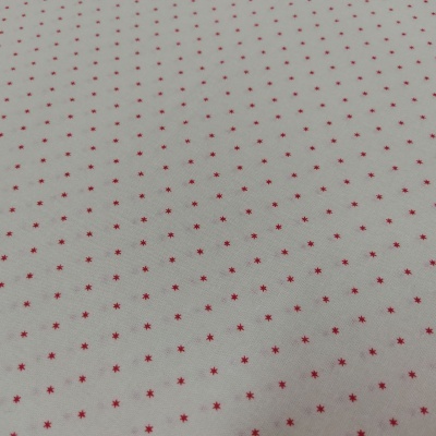 Tecido branco com pequenas estrelas vermelhas