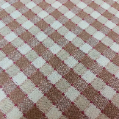 Tecido xadrez bege, branco e castanho com pontos vermelhos cruzados