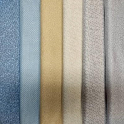 Seis tecidos com padrões pequenos e cores suaves alinhados lado a lado.