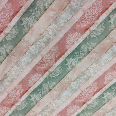 Tecido listrado diagonal verde, rosa e bege com motivos florais brancos
