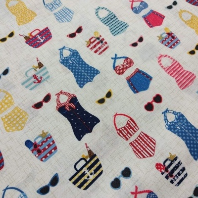 Tecido com padrão colorido de fatos de banho, toalhas e óculos de sol.