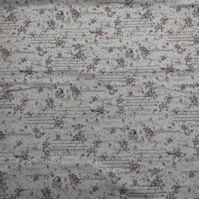 Tecido bege com padrão floral castanho-avermelhado e texto manuscrito impresso.