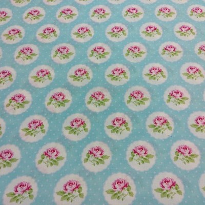 Tecido azul claro com padrão de rosas cor-de-rosa em círculos brancos