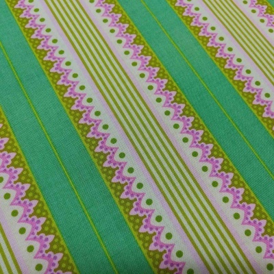 tecido às riscas verde, branco e rosa com padrões de ondas e bolinhas