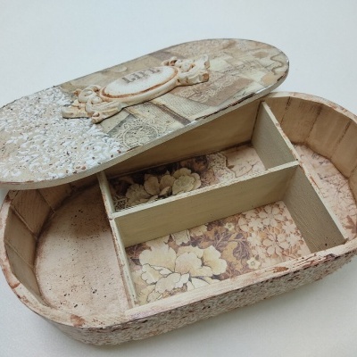 Caixa de madeira oval decorada com padrão floral e tampa destacável