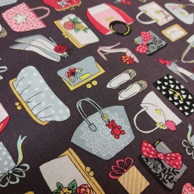 tecido com padrão de acessórios femininos coloridos sobre fundo castanho