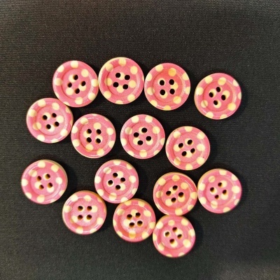 Botões cor-de-rosa com pontos amarelos sobre fundo preto