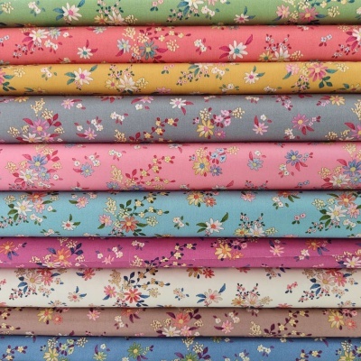 Tecidos de algodão com padrão floral em várias cores empilhados