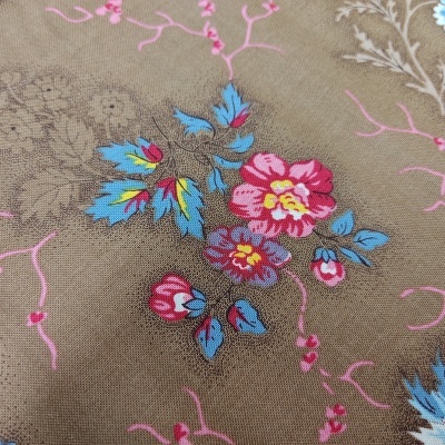 tecido castanho com flores coloridas em rosa, azul e vermelho