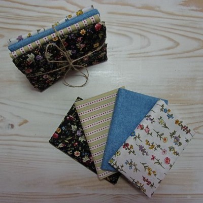 Fabrics com padrões florais e riscas organizados em pilhas sobre madeira