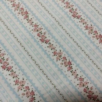 Tecido estampado com listras azuis e flores cor-de-rosa
