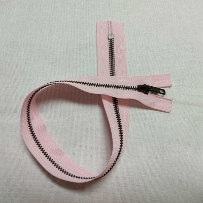 fecho éclair rosa claro com dentes metálicos em tecido branco