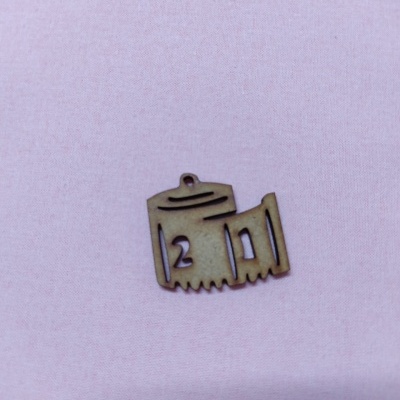 Objeto em madeira forma de fita métrica sobre tecido rosa claro