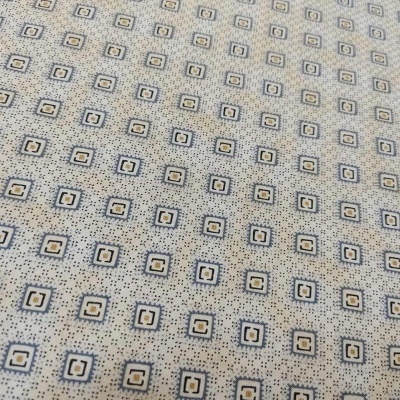 Tecido branco com padrão de pequenos quadrados azuis e amarelos em superfície plana