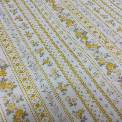 Tecido branco com padrão de flores amarelas e cinzentas em riscas
