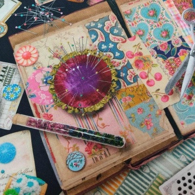 Acessórios de costura e tecidos coloridos dispostos sobre uma superfície.