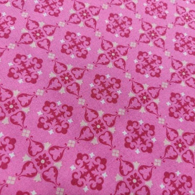 Tecido rosa com padrão de motivos vermelhos e corações
