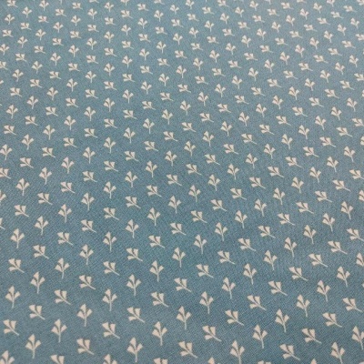 Tecido azul com padrão de pequenos ramos brancos repetitivos