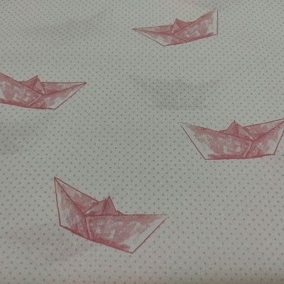 Tecido branco com pequenos pontos cinzentos e barcos de papel rosa estampados.