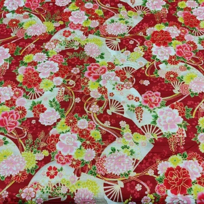 Tecido vermelho com padrão floral e leques coloridos