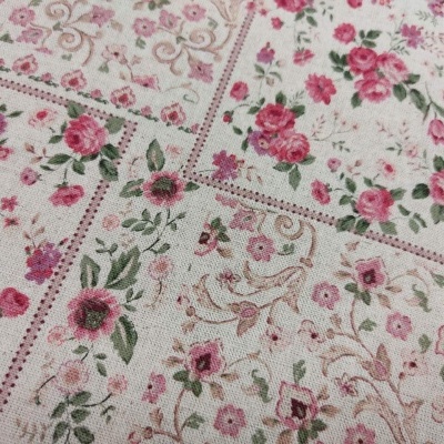Tecido com padrão floral em tons de rosa e verde sobre fundo creme com vários quadros decorativos