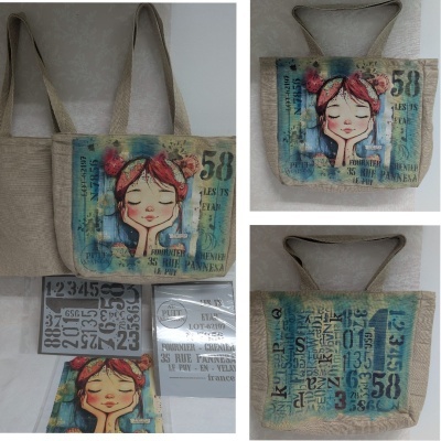 Mala de tecido bege com alça larga e estampa colorida de menina e texto em francês no lado frontal e padrão de números e letras no verso.