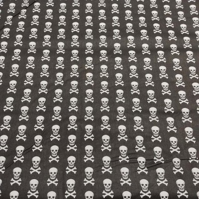 Tecido preto com padrão de caveiras brancas repetidas
