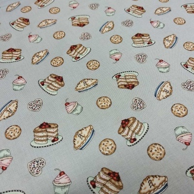 Pano com padrão de doces coloridos sobre fundo cinzento