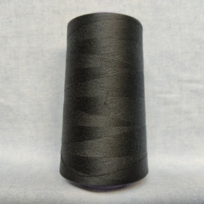 Cone de linha preta em tecido sobre superfície cinzenta