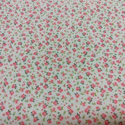 Tecido branco com padrão de pequenas flores vermelhas e rosas e folhas verdes