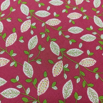 Tecido vermelho com padrão de folhas brancas e verdes