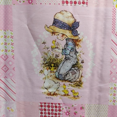 tecido rosa com ilustração de criança e patinhos e padrões de bolinhas e flores