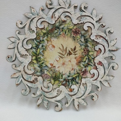 Prato decorativo redondo em metal com padrão floral central e acabamento envelhecido branco