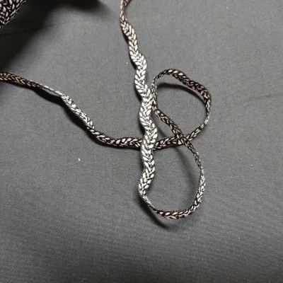 Cordão de tecido preto e branco sobre fundo cinza