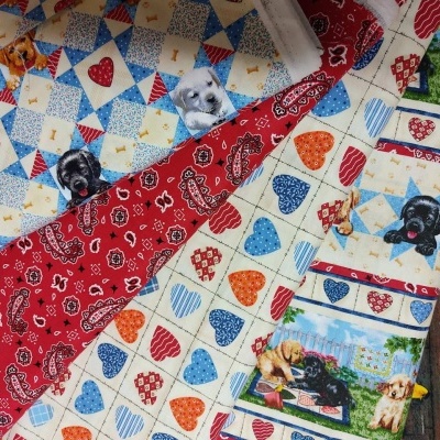 tecidos coloridos com padrões de cães, corações, bandanas e patchwork