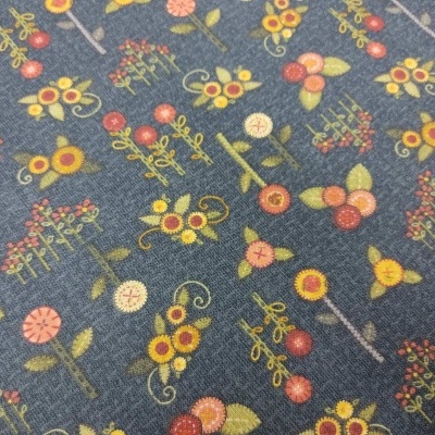 Tecido azul escuro com padrão de flores, frutas e ramos coloridos.