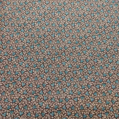 tecido floral castanho com flores azuis e brancas sobre mesa de madeira