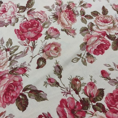 Tecido branco com padrão floral de rosas em tons de rosa e vermelho