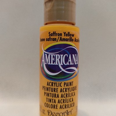 Frasco de tinta acrílica amarela com tampa bege sobre fundo claro