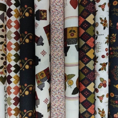 Rolos de tecidos com vários padrões coloridos e texturas visíveis