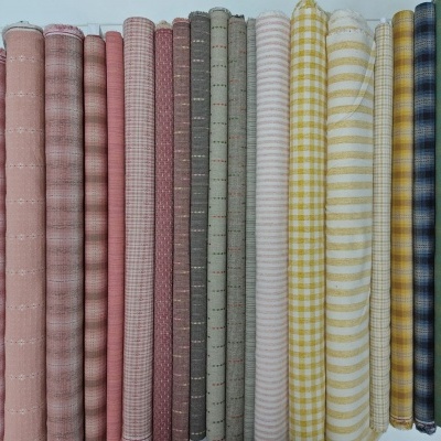 Rolos de tecido de algodão em várias cores e padrões organizados lado a lado