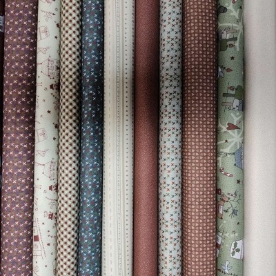 Rolos de tecido coloridos com vários padrões e texturas dispostos lado a lado