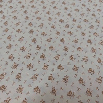 Tecido branco com padrão de pequenas flores castanhas