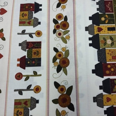 Tecido bordado com casas, flores e corações em faixas verticais