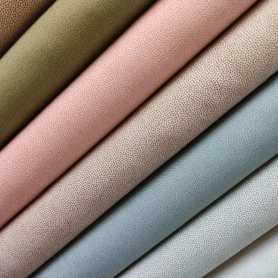 Tecidos em tons pastel com padrão de pequenos pontos pretos