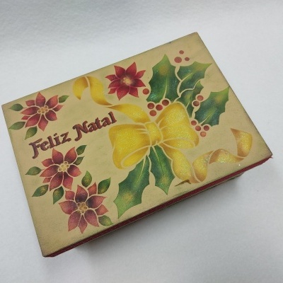 Caixa decorativa de Natal com folhas, flores e texto Feliz Natal