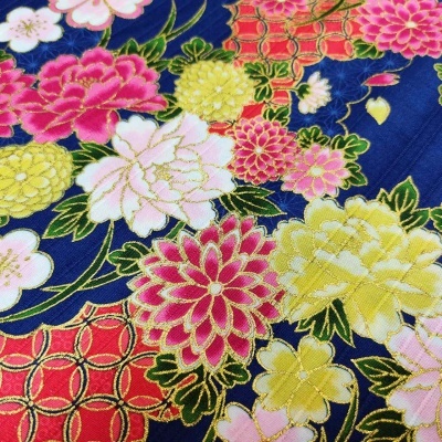 Tecido floral colorido com fundo azul e vermelho e detalhes dourados.