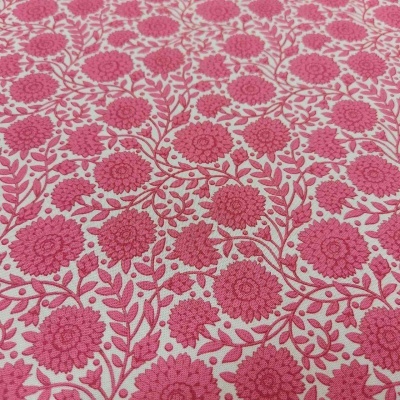 Tecido floral rosa com fundo branco e textura visível