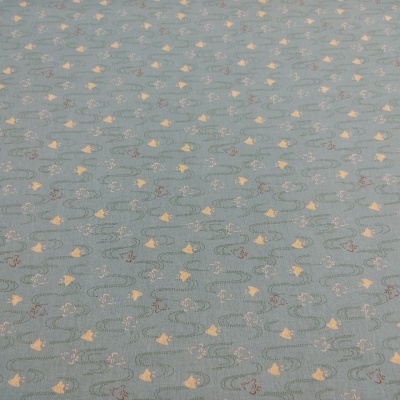 Tecido azul claro com padrão de peixes amarelos e linhas onduladas