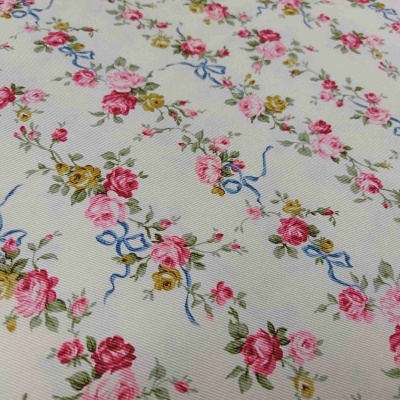 Tecido branco com padrão floral em tons rosa, vermelho, amarelo, verde e azul